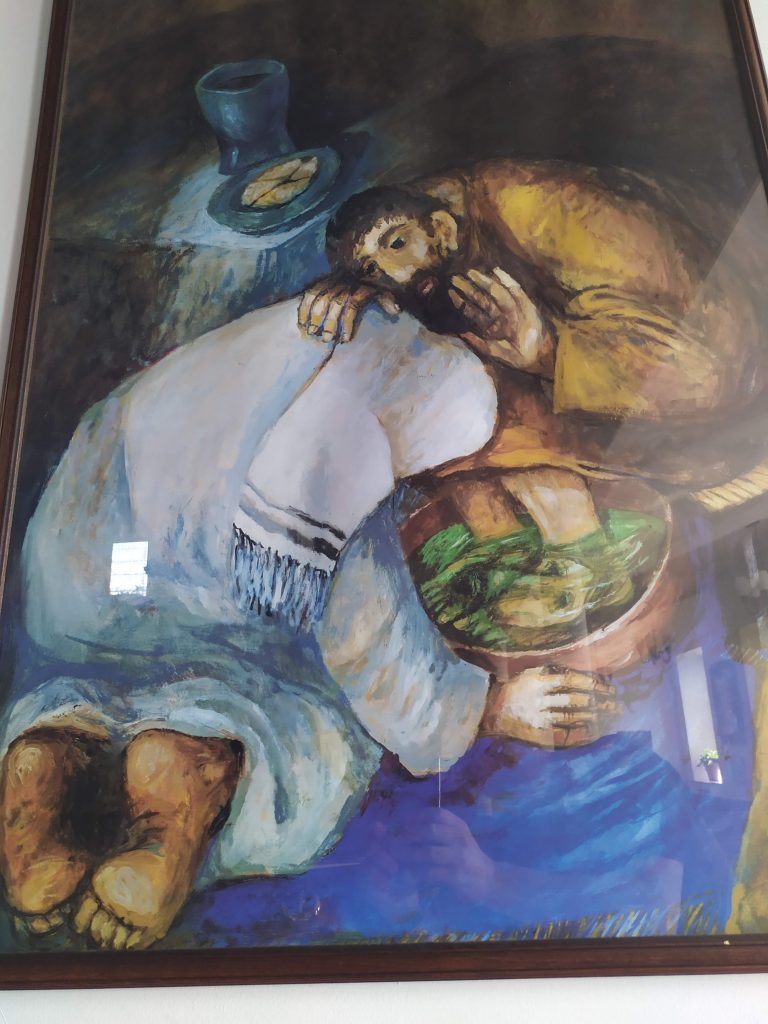 A photograph of a picture hung in St Jame's Church of Jesus washing the feet of his disciples